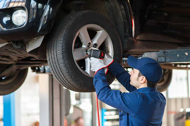 RS681171_GettyImages-504070478 mechanic checking car tyre